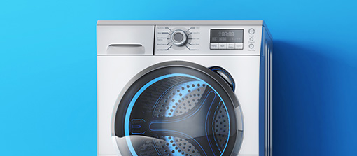 Washing machine sitting next to a blue wall