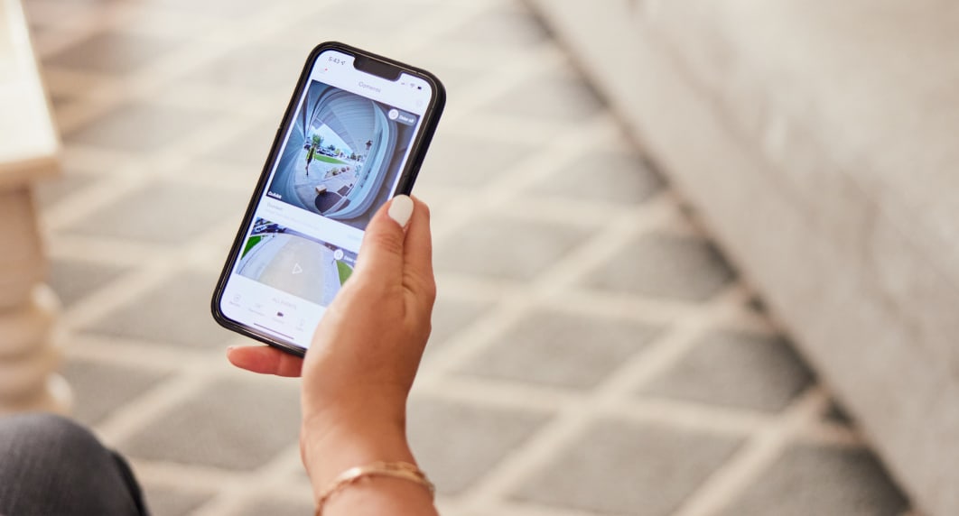 Person holding their cellphone looking at the Vivint app