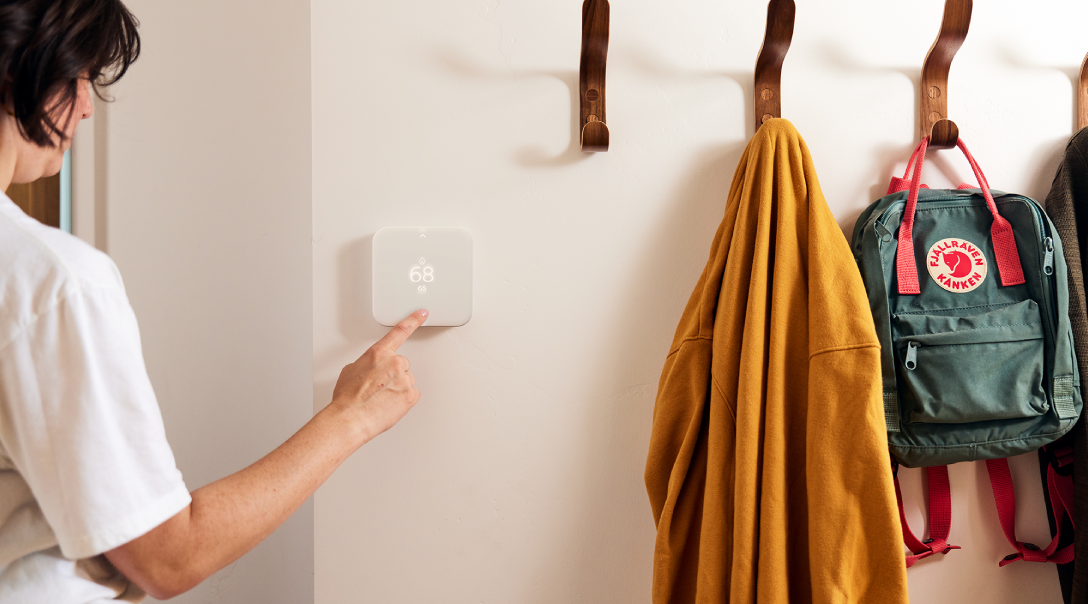 Person adjusting Vivint thermostat